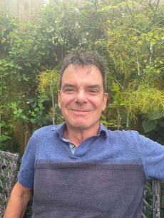 Prof Rob Marchant, in front of a wall of green plants